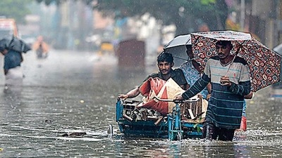 People wade through a flooded street after rainfall in Chennai on Monday. (AFP Photo) People wade through a flooded street after rainfall in Chennai on Monday. (AFP Photo)