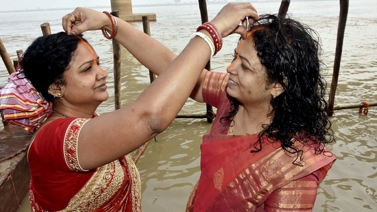 Devotees apply vermillion on each other at the banks of the Ganga river as part of the 'Nahai Khai' ritual in Patna.(ANI)
