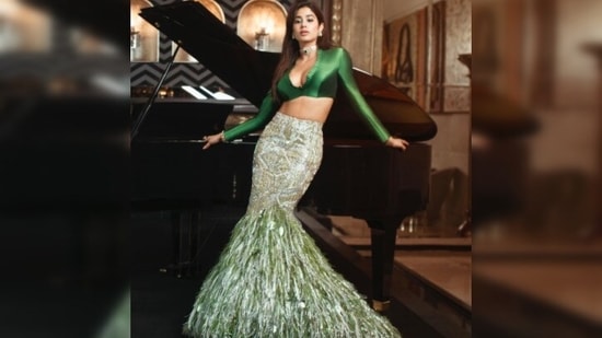 Janhvi Kapoor, in her recent Instagram picture, posed like a boss lady in a green satin crop top and mermaid shaped embellished skirt by ace designer Manish Malhotra.(Instagram/@janhvikapoor)