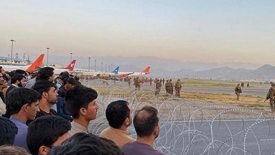 Afghan crowd at the Kabul airport as US soldiers stand guard on August 16. (AFP)