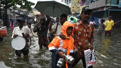 People wade through a flooded street after heavy monsoon rains in Chennai on Monday. (AFP Photo)