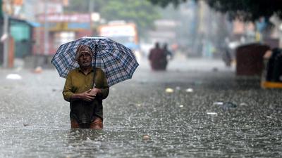 A man holds an umbrella as he wades through a flooded street after heavy monsoon rains in Chennai on November 8, 2021. (AFP Photo) A man holds an umbrella as he wades through a flooded street after heavy monsoon rains in Chennai on November 8, 2021. (AFP Photo)