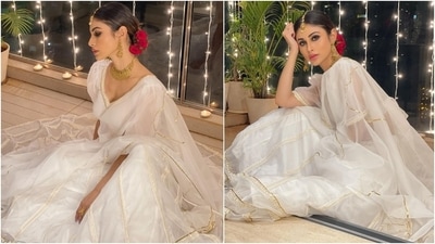The white lehenga set is from Idaho Clothing. It features a plunging neckline blouse with sheer puffed sleeves, embroidered gold and white patti, and a backless detail brought together with a bow tie. Mouni teamed it with an organza lehenga decorated with sleek golden piping and threadwork on borders. (Instagram/@imouniroy) The white lehenga set is from Idaho Clothing. It features a plunging neckline blouse with sheer puffed sleeves, embroidered gold and white patti, and a backless detail brought together with a bow tie. Mouni teamed it with an organza lehenga decorated with sleek golden piping and threadwork on borders. (Instagram/@imouniroy)