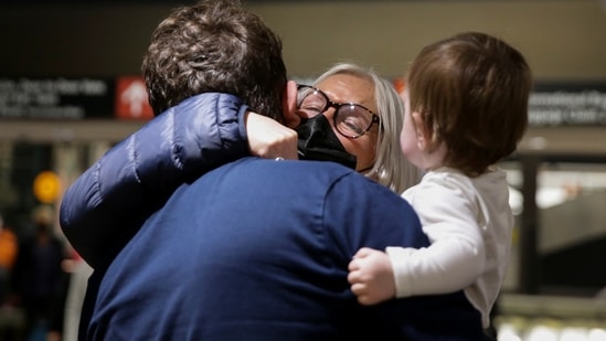 Arriving from a London flight, an elderly women from Scotland hugs her son and granddaughter who she was meeting for the first time, as the United States reopens air and land borders to Covid-19 vaccinated travellers.(REUTERS)