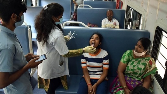 A healthcare worker collects a swab sample of a girl for the Covid-19 test inside a train compartment, in Karnataka’s Bengaluru.