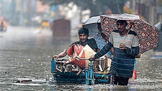 People wade through a flooded street after rainfall in Chennai. (AFP Photo)
