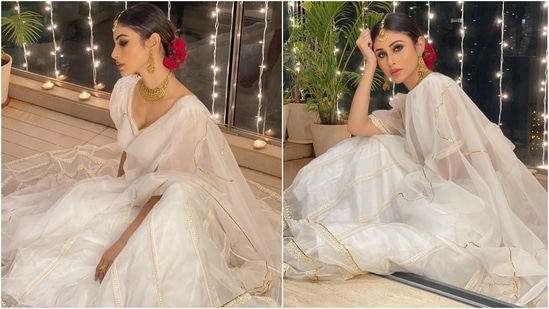 The white lehenga set is from Idaho Clothing. It features a plunging neckline blouse with sheer puffed sleeves, embroidered gold and white patti, and a backless detail brought together with a bow tie. Mouni teamed it with an organza lehenga decorated with sleek golden piping and threadwork on borders.(Instagram/@imouniroy)