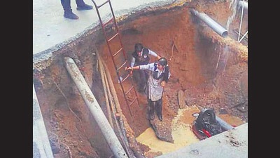 On October 28, a woman and two school-going siblings had a brush with death as they fell into a 15-ft deep crater formed due to a road cave in. Erosion due to damaged sewer lines are being blamed for the road cave-ins. (HT File)