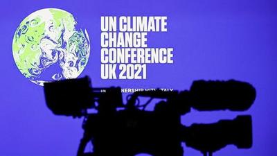A camera is seen in front of a screen displaying the COP26 logo at the UN Climate Change Conference (COP26), in Glasgow, Scotland. (REUTERS) A camera is seen in front of a screen displaying the COP26 logo at the UN Climate Change Conference (COP26), in Glasgow, Scotland. (REUTERS)