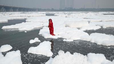 A devotee takes a dip in the waters of Yamuna River as a part of rituals for Chhat Puja amid foam created by pollution in the water in New Delhi on Wednesday. (AFP PHOTO.) A devotee takes a dip in the waters of Yamuna River as a part of rituals for Chhat Puja amid foam created by pollution in the water in New Delhi on Wednesday. (AFP PHOTO.)