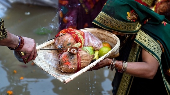 Devotees perform rituals in a makeshift pond during Chhath Puja in East Delhi on Wednesday.(PTI/Manvender Vashist)