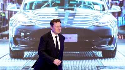 Tesla Inc CEO Elon Musk walks next to a screen showing an image of Tesla Model 3 car, in Shanghai. (Reuters File Photo)