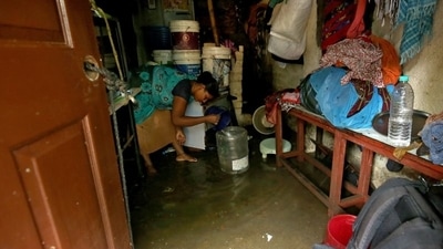 A woman removes rainwater from her house after heavy rainfall batters several parts of Tamil Nadu. (REUTERS)
