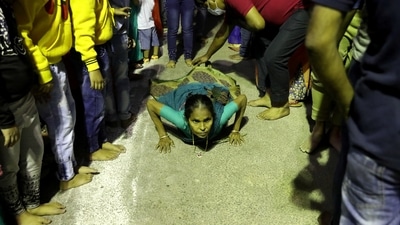 A woman lies on the road as she arrives to worship the Sun God during the religious festival of Chhath Puja in Kolkata. (REUTERS)
