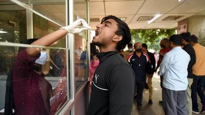 A health worker collects a swab sample of a man for Covid-19 test at District hospital in Noida’s Sector 30. (Sunil Ghosh /HT photo) A health worker collects a swab sample of a man for Covid-19 test at District hospital in Noida’s Sector 30. (Sunil Ghosh /HT photo)