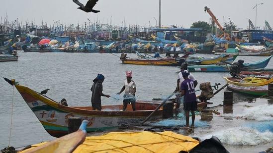 Fisherman mend their net at Kasimedu fishing harbour in Chennai as several parts of Tamil Nadu are likely to witness heavy rainfall for the next few days.(AFP)