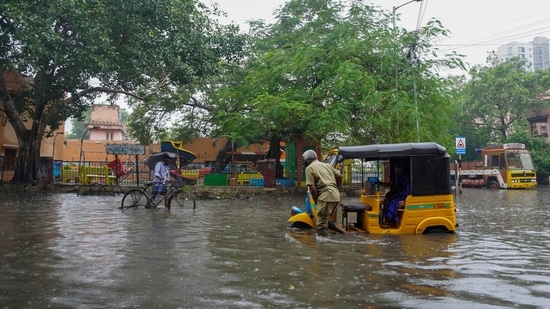A man pushes his autorickshaw past floodwaters on the outskirts of Chennai.(AP)