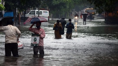 People wade through a waterlogged road following heavy rainfall, in Chennai. (L. Anantha Krishnan) People wade through a waterlogged road following heavy rainfall, in Chennai. (L. Anantha Krishnan)