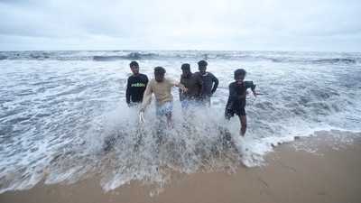 Young men play in the water as waves measuring about two to three metres hit the coast owing to the depression in the Bay of Bengal in Chennai on November 11. (PTI)
