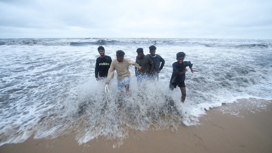 Young men play in the water as waves measuring about two to three metres hit the coast owing to the depression in the Bay of Bengal in Chennai on Thursday.(PTI)