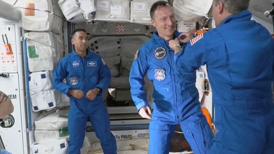 This Nasa TV frame grab image captured on November 11, 2021, shows astronaut Tom Marshburn pin the official flown Nasa astronaut insignia on ESA (European Space Agency) astronaut Matthias Maurer after the Crew-3 Crew Dragon "Endurance" successfully docked with the International Space Station.&nbsp;(AFP)