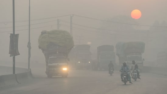 Commuters make their way amid smoggy conditions in Lahore. (Photo by Arif ALI / AFP)