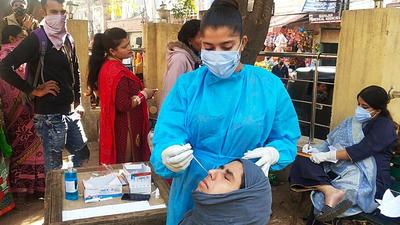 A healthcare worker collects a swab sample of a woman for Covid testing in Jammu. (ANI File)