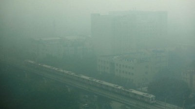 A metro train passes through the Rajiv Gandhi Cancer Institute and Research Center as it approaches Rithala metro station on a smoggy morning in Delhi.&nbsp; (REUTERS)