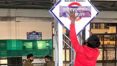 A worker installs a nameplate after Habibganj railway station was renamed as Rani Kamlapati railway station, in Bhopal, on Saturday. (PTI)