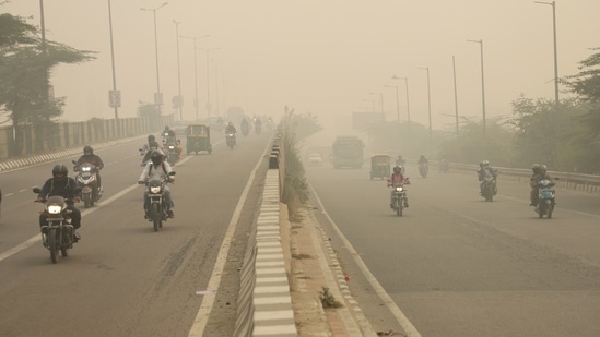 Commuters travel amidst dense smog during morning hours as pollution persists in the city, in New Delhi on Friday. (Amit Sharma)