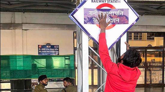 A worker installs a nameplate after Habibganj railway station was renamed as Rani Kamlapati railway station, in Bhopal, on Saturday. (PTI)