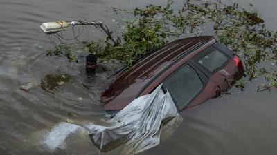 People trying to recover a car that fell into a river after an embankment caved in following heavy rainfall in Kochi in Kerala on Sunday. There were no occupants in the car that was parked at a service center. The southern state has been receiving very heavy rain for the past two days. (AP PHOTO.) People trying to recover a car that fell into a river after an embankment caved in following heavy rainfall in Kochi in Kerala on Sunday. There were no occupants in the car that was parked at a service center. The southern state has been receiving very heavy rain for the past two days. (AP PHOTO.)