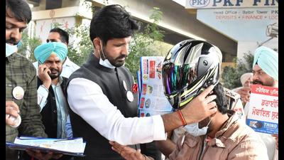 Punjab transport minister gives a helmet to a traffic rules violator in Jalandhar on Sunday. (HT Photo) Punjab transport minister gives a helmet to a traffic rules violator in Jalandhar on Sunday. (HT Photo)