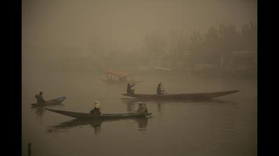 Boatmen row their boats during a cold and foggy morning in Srinagar on Sunday as temperature continues to dip in Kashmir valley.