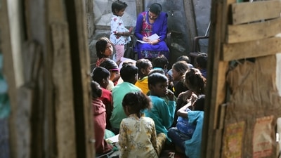 A teacher teaches children at a slum area on the eve of Children's Day, on the outskirts of Jammu. (PTI) A teacher teaches children at a slum area on the eve of Children's Day, on the outskirts of Jammu. (PTI)