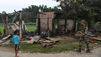 A paramilitary soldier patrols past a shop that was set on fire in Rowa village, about 220 kilometers from Agartala, in Tripura, on Oct. 27 2021. (AP)