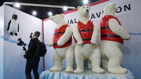 A man documents a hanged penguin representation at the Tuvalu pavilion during the UN Climate Change Conference (COP26) in Glasgow, Scotland.&nbsp;(REUTERS)