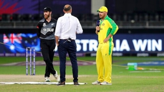 New Zealand's captain Kane Williamson, left, reacts as Australia's captain Aaron Finch, right, talks to the commentator after winning the toss ahead of their Cricket Twenty20 World Cup final match between New Zealand and Australia in Dubai, UAE, Sunday, Nov. 14, 2021. (AP Photo/Aijaz Rahi)(AP)