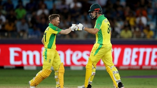 Australia's Mitchell Marsh, right, fist bumps David Warner playing without his helmet after taking it off during the Cricket Twenty20 World Cup final match between Australia and New Zealand in Dubai, UAE, Sunday, Nov. 14, 2021.&nbsp;(AP)