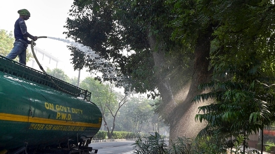A worker sprays water on trees as part of efforts to curb air pollution, in New Delhi.&nbsp;(PTI Photo)