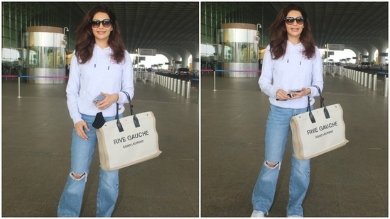 Karishma wore the ensemble with chunky white lace-up sneakers, a black face mask, sunglasses, and a classy watch. She also carried a Yves Saint Laurent Rive Gauche Tote Bag in an off-white and beige shade.(HT Photo/Varinder Chawla)