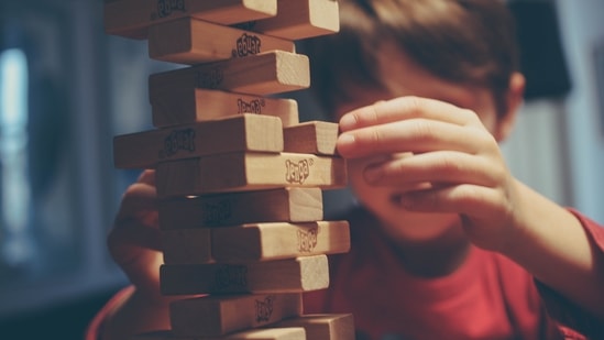 Play board games together: Spending time with your child is the biggest gift anyone can give to their young ones on Children's Day. Play some board games like chess, ludo, scrabbles, chess, carom board etc, create conversations with them and get to know them better.(Unsplash)