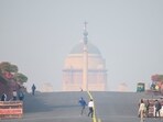 People walk near Rashtrapati Bhavan amid smoggy conditions in New Delhi. (AFP Photo)