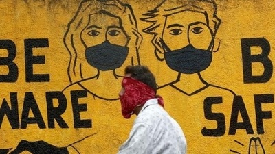 A man walks past a graffiti amid the spread of the coronavirus disease in Mumbai. (Reuters file photo) A man walks past a graffiti amid the spread of the coronavirus disease in Mumbai. (Reuters file photo)
