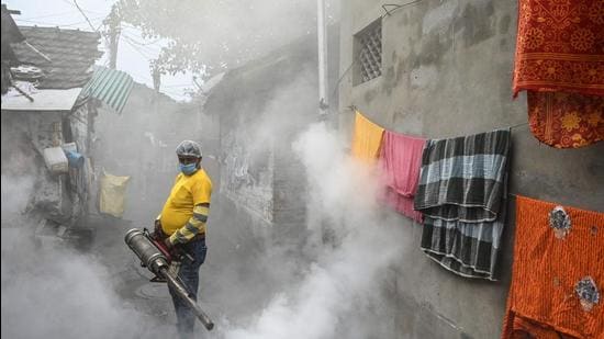 A municipal worker fumigates a slum area as a preventive measure against mosquito-born diseases in Kolkata on November 15, 2021. (Photo by DIBYANGSHU SARKAR / AFP) (AFP)
