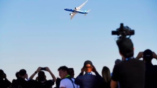 A crowd watches a Boeing 777X fly at the Dubai Air Show. This year, the five-day exhibition is expected to be much more muted than in the past years due to the subdued state of flying and travel amid the Covid-19 pandemic and delays in the global supply chain that have affected plane manufacturers.(AP)