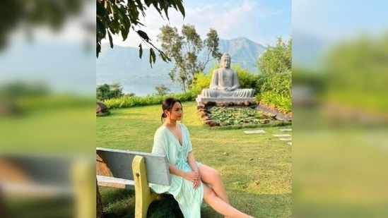 Sonakshi Sinha relaxes under a tree with a statue of Gautam Buddha next to her.(Instagram/@aslisona)