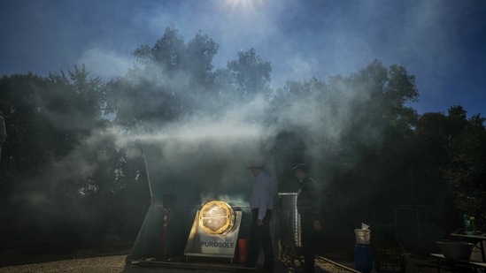 The engineers overlook the functioning of the Purosole, Pure Sun, solar light coffee roaster,(AP Photo/Andrew Medichini)