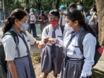 Students maintain social distancing and greet each other with fist bumps as they arrive at a school to attend class after after 20 months in West Bengal.(PTI)