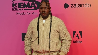 French DJ Kiddy Smile arrives at the MTV Europe Music Awards wearing beige joggers and jacket set. (AFP)